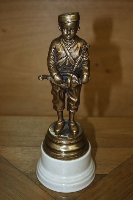 SUJET EN BRONZE DORE REPRESENTANT UN JOUEUR DE VIOLE SUR UN SOCLE EN PORCELAINE BLANC. HAUT. 28 CM.