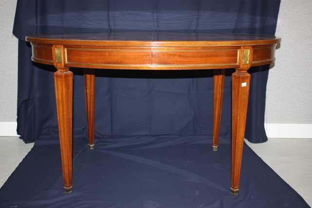 TABLE DE SALLE A MANGER DE FORME OVALE EN BOIS DE PLACAGE, PIEDS FORMANT GAINE, BAGUETTES EN LAITON DORE, AVEC TROIS RALLONGES.
DIM : 75 X 134 X 90 CM.
STYLE LOUIS XVI.