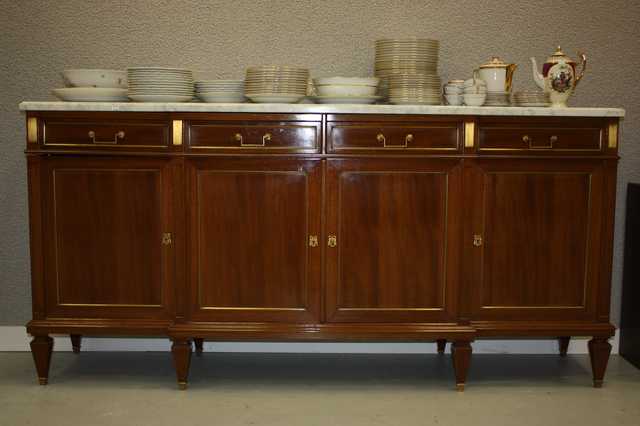 ENFILADE EN BOIS DE PLACAGE ET BAGUETTES EN LAITON DORE OUVRANT PAR QUATRE TIROIRS ET QUATRE PLACARDS. PIEDS FORMANT GAINES, PLATEAU DE MARBRE BLANC.
DIM : 100 X 208 X 50 CM.