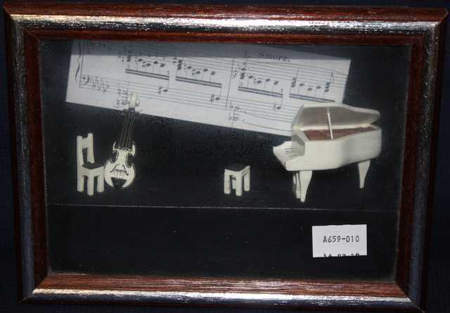 PETITE PIECE ENCADRE A DECOR MINIATURE D'INSTRUMENTS DE MUSIQUE.