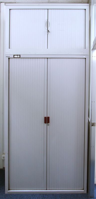 1 GRANDE ARMOIRE METALLIQUE A PORTES RIDEAUX DE COULEUR GRISE AVEC CHAPEAU. HAUT : 240 ; LARG : 100 ; PROF : 45 CM. LOT VENDU A L'UNITE AVEC FACULTE DE REUNION.