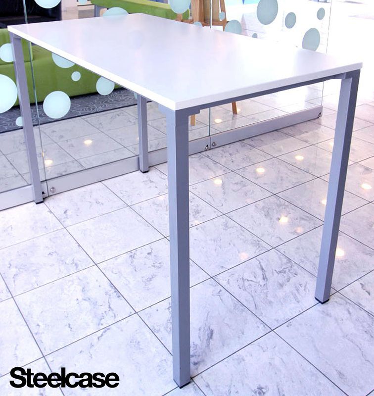 TABLE HAUTE DE MARQUE STEELCASE, PLATEAU RECTANGULAIRE EN BOIS LAQUE BLANC, PIETEMENT EN METAL GRIS. 105 X 160 X 80 CM. R0 CAFET