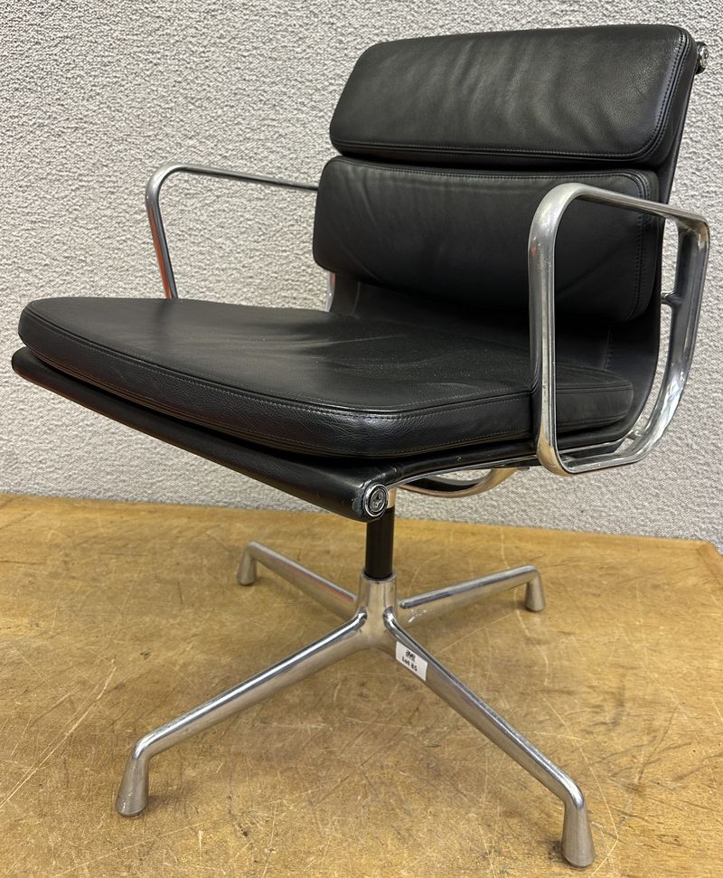 FAUTEUIL PIVOTANT DESIGN CHARLES ET RAY EAMES MODELE SOFT PAD EA208 EDITION VITRA, STRUCTURE EN ALUMINIUM, GARNITURE EN CUIR NOIR REPOSANT SUR UN PIETEMENT EN ETOILE A 4 BRANCHES SUR PATINS. USURES. 84 X 58 X 69 CM.