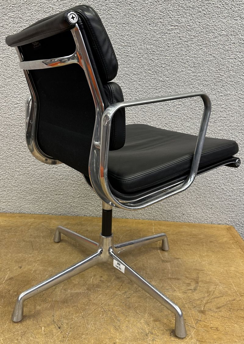 FAUTEUIL PIVOTANT DESIGN CHARLES ET RAY EAMES MODELE SOFT PAD EA208 EDITION VITRA, STRUCTURE EN ALUMINIUM, GARNITURE EN CUIR NOIR REPOSANT SUR UN PIETEMENT EN ETOILE A 4 BRANCHES SUR PATINS. USURES. 84 X 58 X 69 CM.