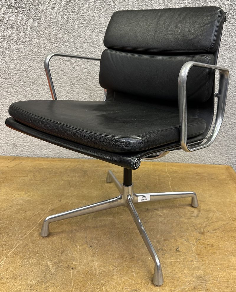 FAUTEUIL PIVOTANT DESIGN CHARLES ET RAY EAMES MODELE SOFT PAD EA208 EDITION VITRA, STRUCTURE EN ALUMINIUM, GARNITURE EN CUIR NOIR REPOSANT SUR UN PIETEMENT EN ETOILE A 4 BRANCHES SUR PATINS. USURES. 84 X 58 X 69 CM.