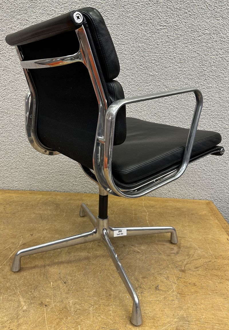 FAUTEUIL PIVOTANT DESIGN CHARLES ET RAY EAMES MODELE SOFT PAD EA208 EDITION VITRA, STRUCTURE EN ALUMINIUM, GARNITURE EN CUIR NOIR REPOSANT SUR UN PIETEMENT EN ETOILE A 4 BRANCHES SUR PATINS. SANS PATINS. USURES. 84 X 58 X 69 CM.