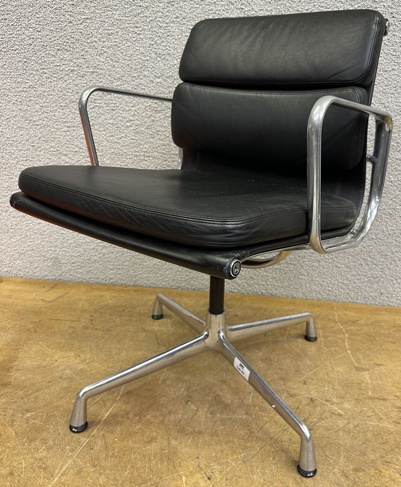 FAUTEUIL PIVOTANT DESIGN CHARLES ET RAY EAMES MODELE SOFT PAD EA208 EDITION VITRA, STRUCTURE EN ALUMINIUM, GARNITURE EN CUIR NOIR REPOSANT SUR UN PIETEMENT EN ETOILE A 4 BRANCHES SUR PATINS. USURES. 84 X 58 X 69 CM.