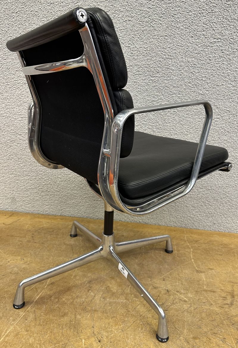 FAUTEUIL PIVOTANT DESIGN CHARLES ET RAY EAMES MODELE SOFT PAD EA208 EDITION VITRA, STRUCTURE EN ALUMINIUM, GARNITURE EN CUIR NOIR REPOSANT SUR UN PIETEMENT EN ETOILE A 4 BRANCHES SUR PATINS. USURES. 84 X 58 X 69 CM.