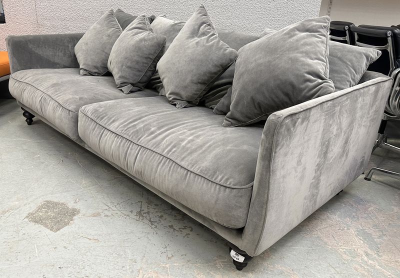 CANAPE 4 PLACES GRANDE PROFONDEUR EN TISSUS VELOURS DE COULEUR GRIS TAUPE DE MARQUE AM-PM MODELE ASVELOURS REPOSANT SUR 5 PIEDS EN BOIS NATUREL TOURNE ET 8 COUSSINS. 64 X 217 X 99 CM.