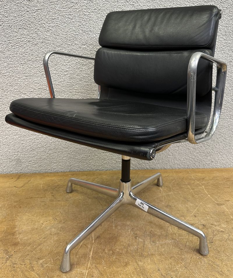 FAUTEUIL PIVOTANT DESIGN CHARLES ET RAY EAMES MODELE SOFT PAD EA208 EDITION VITRA, STRUCTURE EN ALUMINIUM, GARNITURE EN CUIR NOIR REPOSANT SUR UN PIETEMENT EN ETOILE A 4 BRANCHES SUR PATINS. USURES. 84 X 58 X 69 CM.