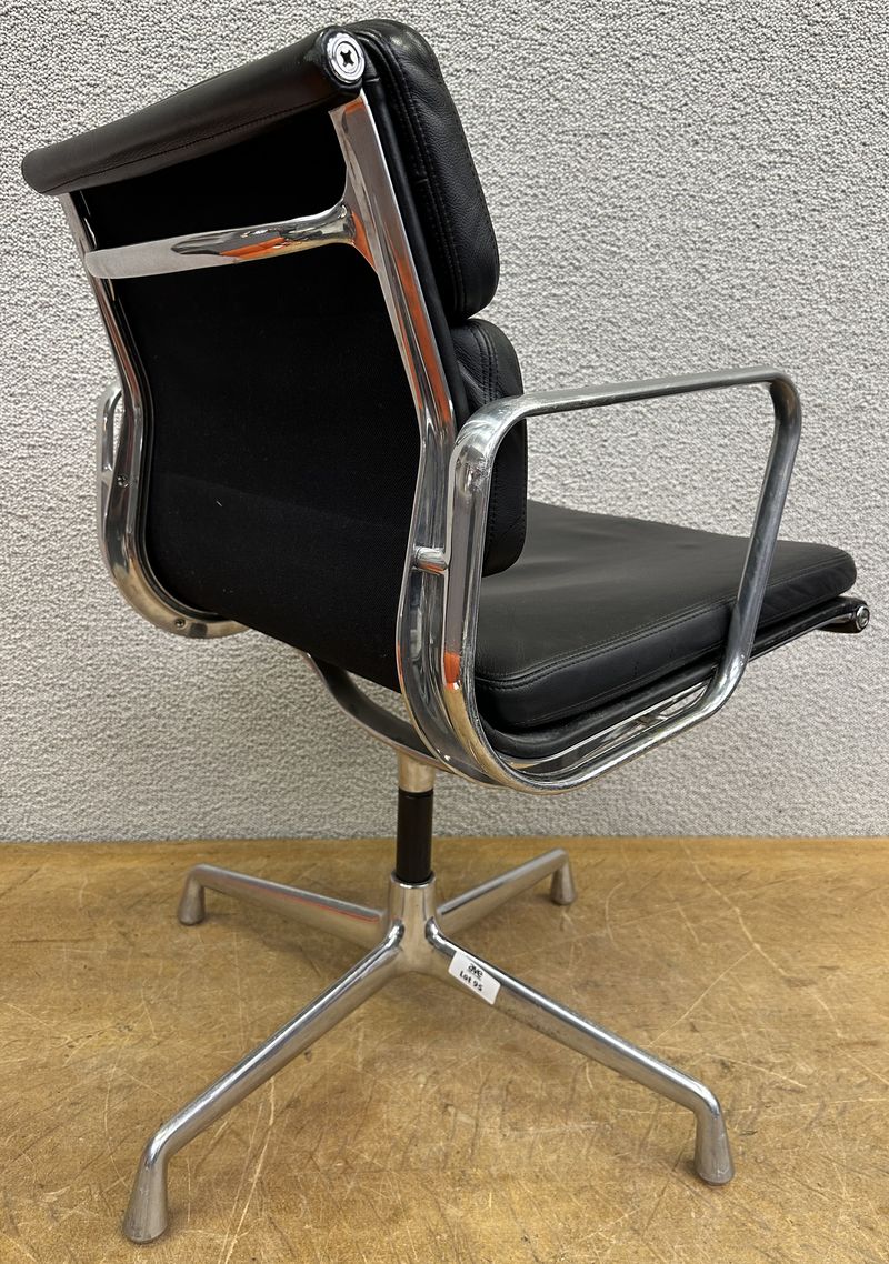 FAUTEUIL PIVOTANT DESIGN CHARLES ET RAY EAMES MODELE SOFT PAD EA208 EDITION VITRA, STRUCTURE EN ALUMINIUM, GARNITURE EN CUIR NOIR REPOSANT SUR UN PIETEMENT EN ETOILE A 4 BRANCHES SUR PATINS. USURES. 84 X 58 X 69 CM.