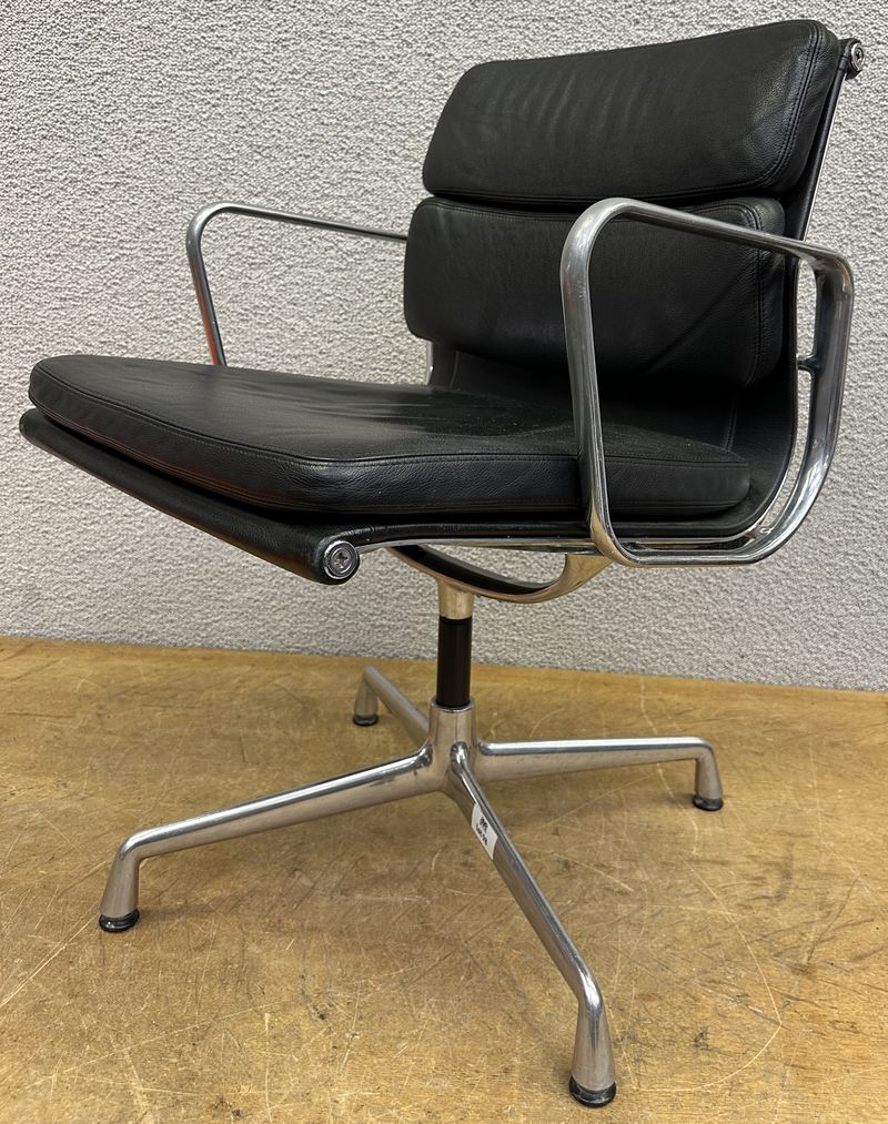 FAUTEUIL PIVOTANT DESIGN CHARLES ET RAY EAMES MODELE SOFT PAD EA208 EDITION VITRA, STRUCTURE EN ALUMINIUM, GARNITURE EN CUIR NOIR REPOSANT SUR UN PIETEMENT EN ETOILE A 4 BRANCHES SUR PATINS. USURES. 84 X 58 X 69 CM.