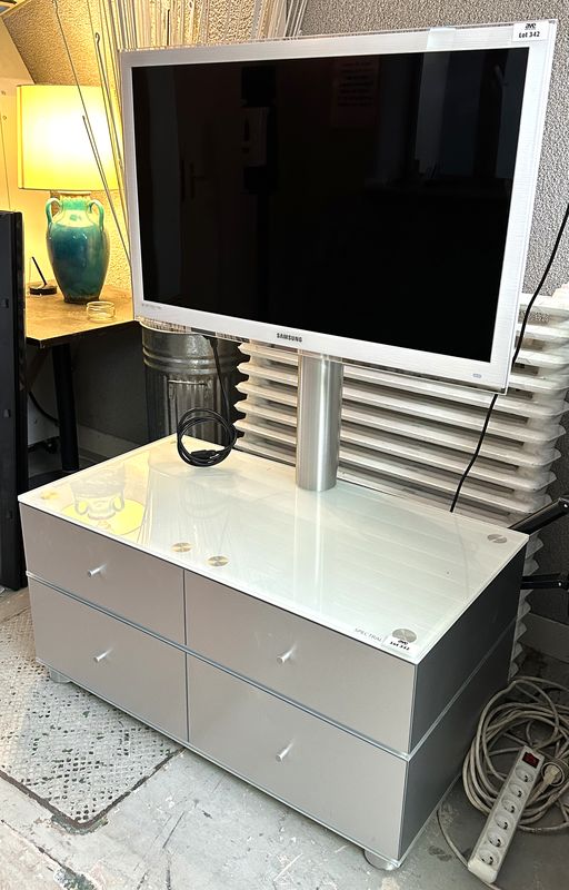 TELEVISION CONNECTEE A ECRAN LED FHD DE 40 POUCES DE MARQUE SAMSUNG MODELE UE40C6710US REPOSANT SUR UN MEUBLE A SUPPORT ECRAN EN INOX BROSSE STRUCTURE EN BOIS MDF LAQUE GRIS, PLATEAU EN VERRE OPALINE DE COULEUR BLANCHE OUVRANT PAR 4 CASIERS DE RANGEMENT A CLAPETS. VENDU AVEC TELECOMMANDE, CABLE D'ALIMENTATION, RJ45, COAXIAL ET VIDEO. DIMENSIONS TOTALES : 145 X 101 X 55 CM.