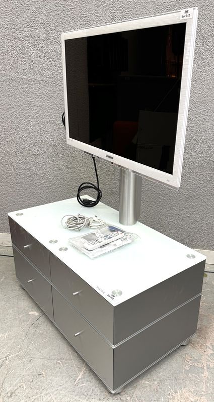 TELEVISION CONNECTEE A ECRAN LED FHD DE 40 POUCES DE MARQUE SAMSUNG MODELE UE40C6710US REPOSANT SUR UN MEUBLE A SUPPORT ECRAN EN INOX BROSSE STRUCTURE EN BOIS MDF LAQUE GRIS, PLATEAU EN VERRE OPALINE DE COULEUR BLANCHE OUVRANT PAR 4 CASIERS DE RANGEMENT A CLAPETS. VENDU AVEC TELECOMMANDE, CABLE D'ALIMENTATION, RJ45, COAXIAL ET VIDEO. DIMENSIONS TOTALES : 145 X 101 X 55 CM.