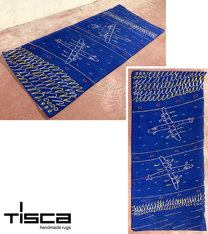 TAPIS DE MARQUE TISCA EN LAINE A FOND DE COULEUR BLEU A MOTIF D'UNE SCENE AEROPORTUAIRE. 247 X 100 CM. ARCUEIL SOUS-SOL POSTE