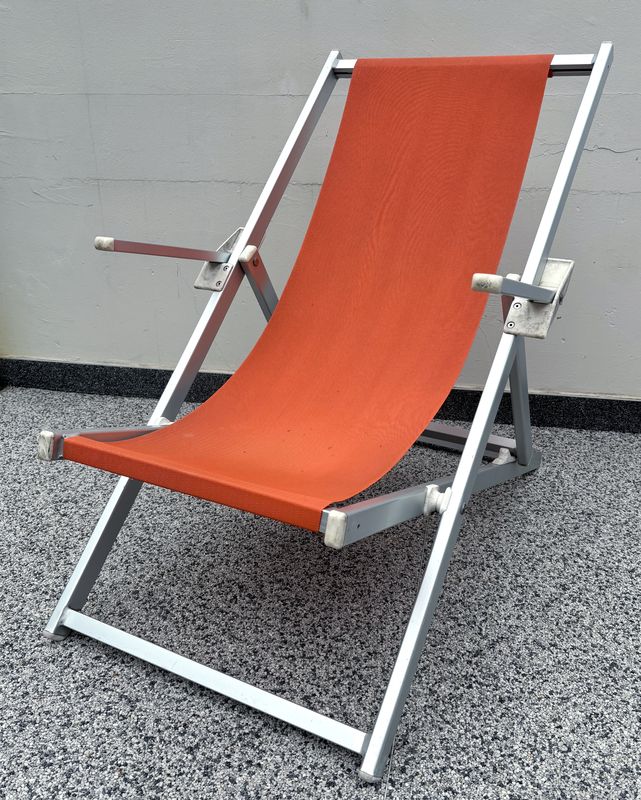 X17 CHILIENNE OU TRANSAT OU CHAISE LONGUE EN ALUMINIUM ANODISE DE COULEUR GRIS ET TISSUS TENDU DE COULEUR ORANGE DE MARQUE ROLAND VLAEMYNCK MODELE ALPINA. 103.5 X 65.5 X 106 CM.