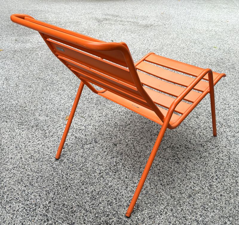 FAUTEUIL DE JARDIN DE MARQUE FERMOB MODELE FAUTEUIL BAS MONCEAU EN ACIER LAQUE ORANGE. 43 X 52.5 X 92 CM.