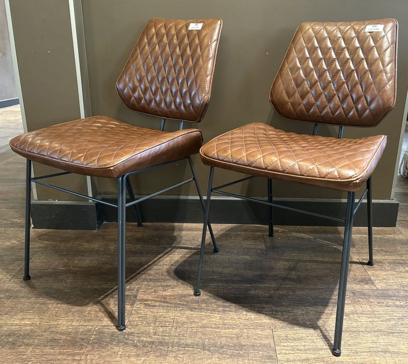 X2 PAIRE DE CHAISES DE STYLE ANNEE 1950, ASSISE ET DOSSIER EN SIMILI CUIRE MATELASSE DE COULEUR CHOCOLAT ET PIETEMENT EN TIGES D'ACIER DE COULEUR NOIR. USURES D'USAGE. 79.5 X 57 X 47 CM.