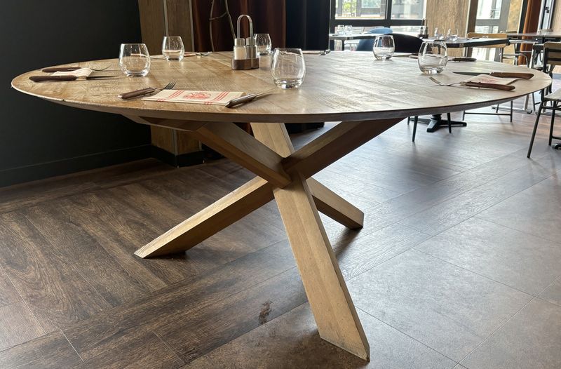 GRANDE TABLE DE SALLE A MANGER DESIGN ALAIN VAN HAVRE MODLEE TABLE CIRCLE EDITION ETHNICRAFT DE STYLE SCANDINAVE, PLATEAU CIRCULAIRE ET PIETEMENT EN CROIX DE SAINT ANDRE EN CHENE NATUREL. 75 X 163 CM.