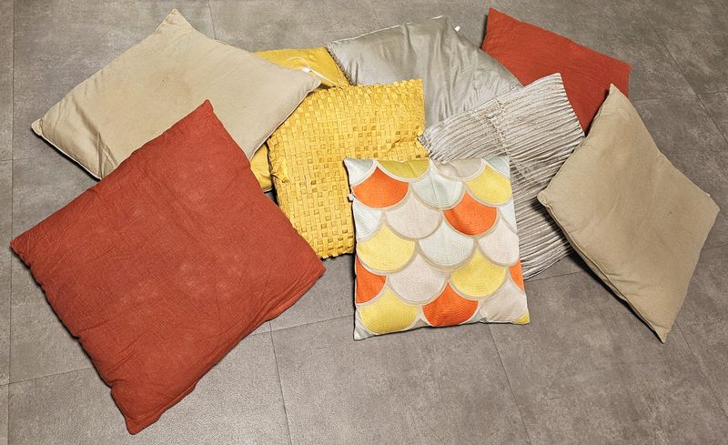 22 COUSSINS DEHOUSSABLES EN TISSU SATIN OU COTON DE COULEUR OCRE, BEIGE ET ROUGE DIVERS MODELE DE MARQUE HABITAT. 45 X 45 CM ET 40 X 40 CM. LOCALISATION -> BAT A : -1 SE; BAT B : STOCK DELTA 2