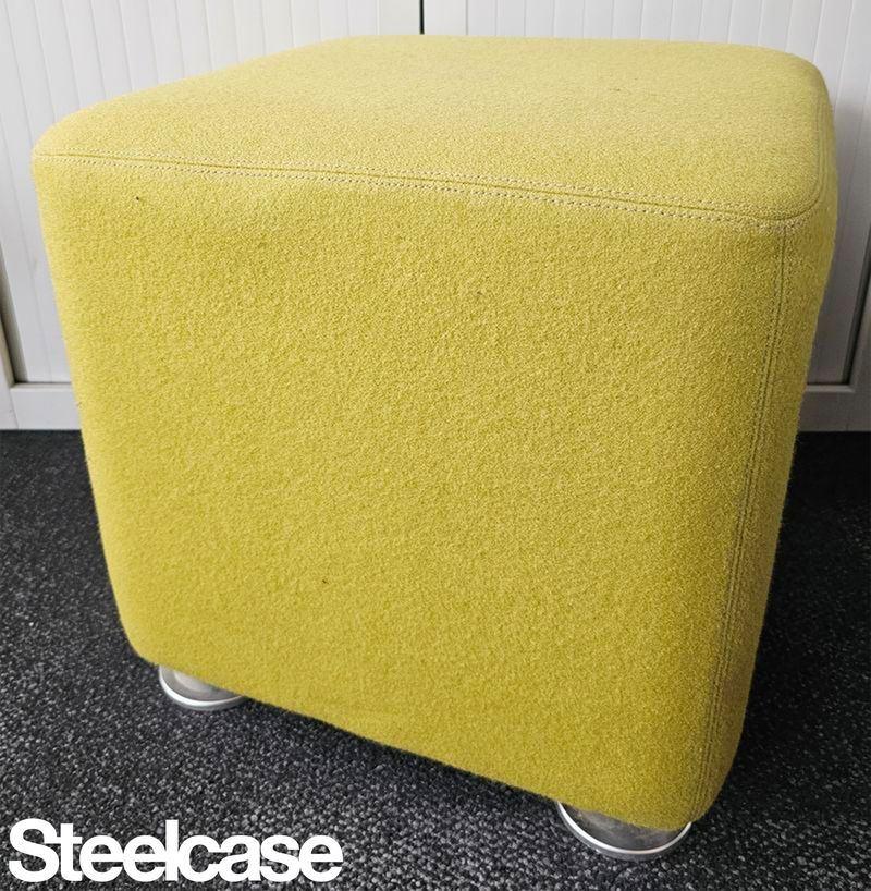 POUF CARRE DE MARQUE STEELCASE MODELE B-FREE EN FEUTRINE DE COULEUR JAUNE MOUTARDE REPOSANT SUR 4 PATINS EN ACIER LAQUE GRIS. 42 X 42 CM. LOCALISATION -> BAT A : 3