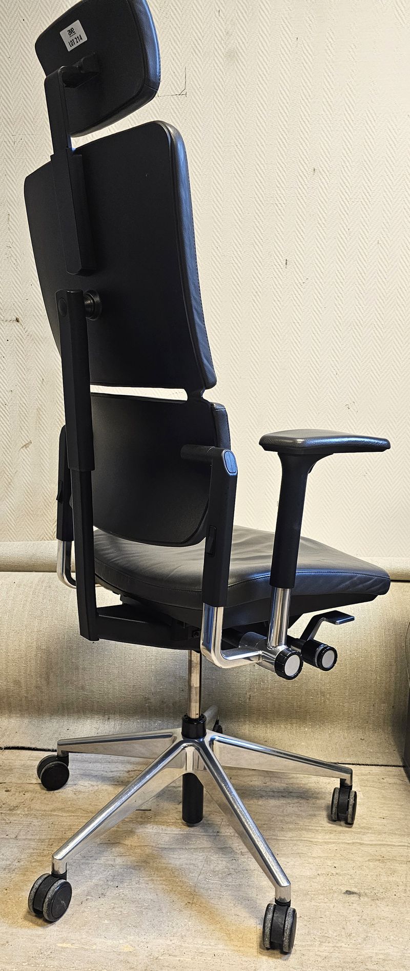 FAUTEUIL ERGONOMIQUE SUR ROULETTE A HAUTEUR ET TETIERE AJUSTABLE, ASSISE, DOSSIER, TETIERE ET ACCOUDOIRS EN CUIR DE COULEUR NOIR REPOSANT SUR UN PIETEMENT ETOILE A 5 BRANCHE EN ACIER CHROME DE MARQUE STEELCASE MODELE PLEASE. HAUTEUR MAX : 140 CM, HAUTEUR MIN : 128 CM, 70 X 63 CM. LOCALISATION -> BAT B : STOCK DELTA