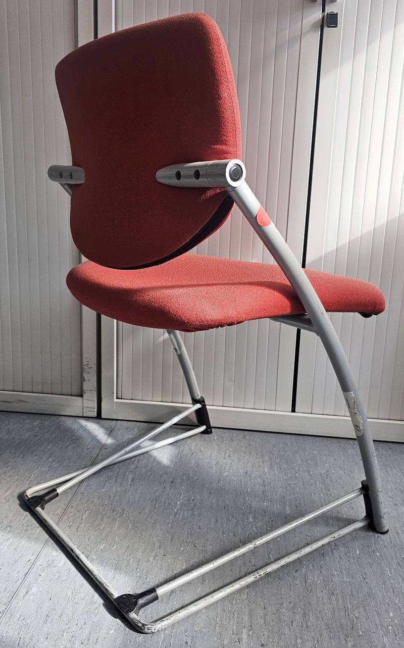 CHAISE DE MARQUE STEELCASE MODELE STRAFOR DESIGN 2000 ASSISE ET DOSSIER EN TISSU DE COULEUR ROUGE REPOSANT SUR UNE STRUCTURE ET UN PIETEMENT LUGE EN ACIER LAQUE GRIS. 82 X 52 X 48 CM. TACHE. 4 UNITES. VENDU A L'UNITE AVEC FACULTE DE REUNION. LOCALISATION -> BAT H : 2