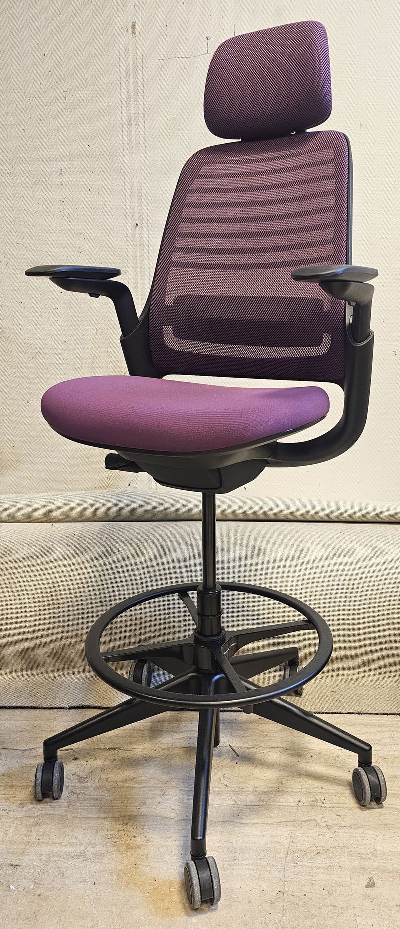 FAUTEUIL DE BUREAU HAUT A HAUTEUR AJUSTABLE ET TETIERE, SOUTIEN LOMBAIRE DE MARQUE STEELCASE MODELE SERIES 1 DOSSIER EN RESILLE DE COULEUR VOILETTE, ASSISE ET TETIERE EN TISSU DE COULEUR VIOLETTE REPOSANT SUR UN PIETEMENT ETOILE A ROULETTES ET UN REPOSE PIED EN ACIER LAQUE NOIR. HAUTEUR MIN : 96 CM, HAUTEUR MAX : 106 CM, 70 X 66 CM. 2 UNITES. VENDU A L'UNITE AVEC FACULTE DE REUNION. LOCALISATION -> BAT B : STOCK DELTA