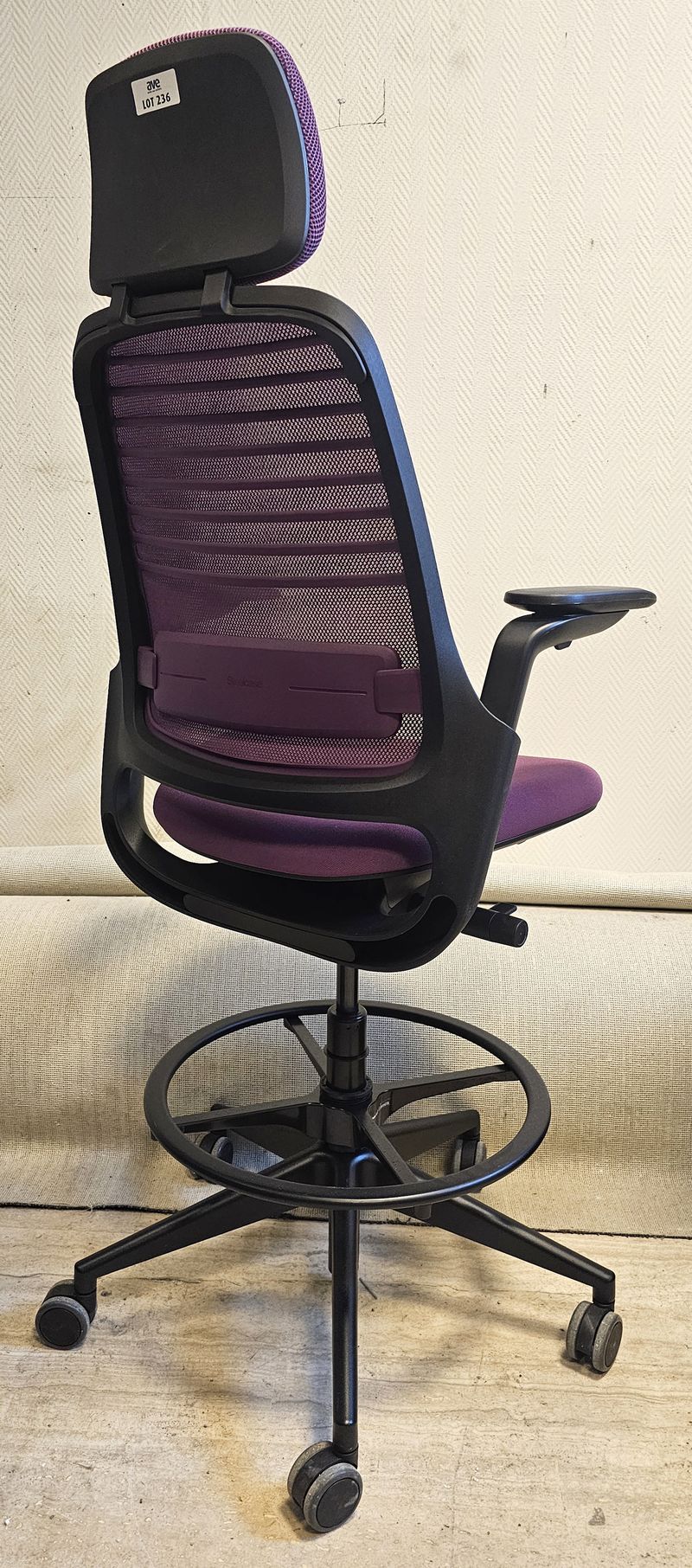 FAUTEUIL DE BUREAU HAUT A HAUTEUR AJUSTABLE ET TETIERE, SOUTIEN LOMBAIRE DE MARQUE STEELCASE MODELE SERIES 1 DOSSIER EN RESILLE DE COULEUR VOILETTE, ASSISE ET TETIERE EN TISSU DE COULEUR VIOLETTE REPOSANT SUR UN PIETEMENT ETOILE A ROULETTES ET UN REPOSE PIED EN ACIER LAQUE NOIR. HAUTEUR MIN : 96 CM, HAUTEUR MAX : 106 CM, 70 X 66 CM. 2 UNITES. VENDU A L'UNITE AVEC FACULTE DE REUNION. LOCALISATION -> BAT B : STOCK DELTA