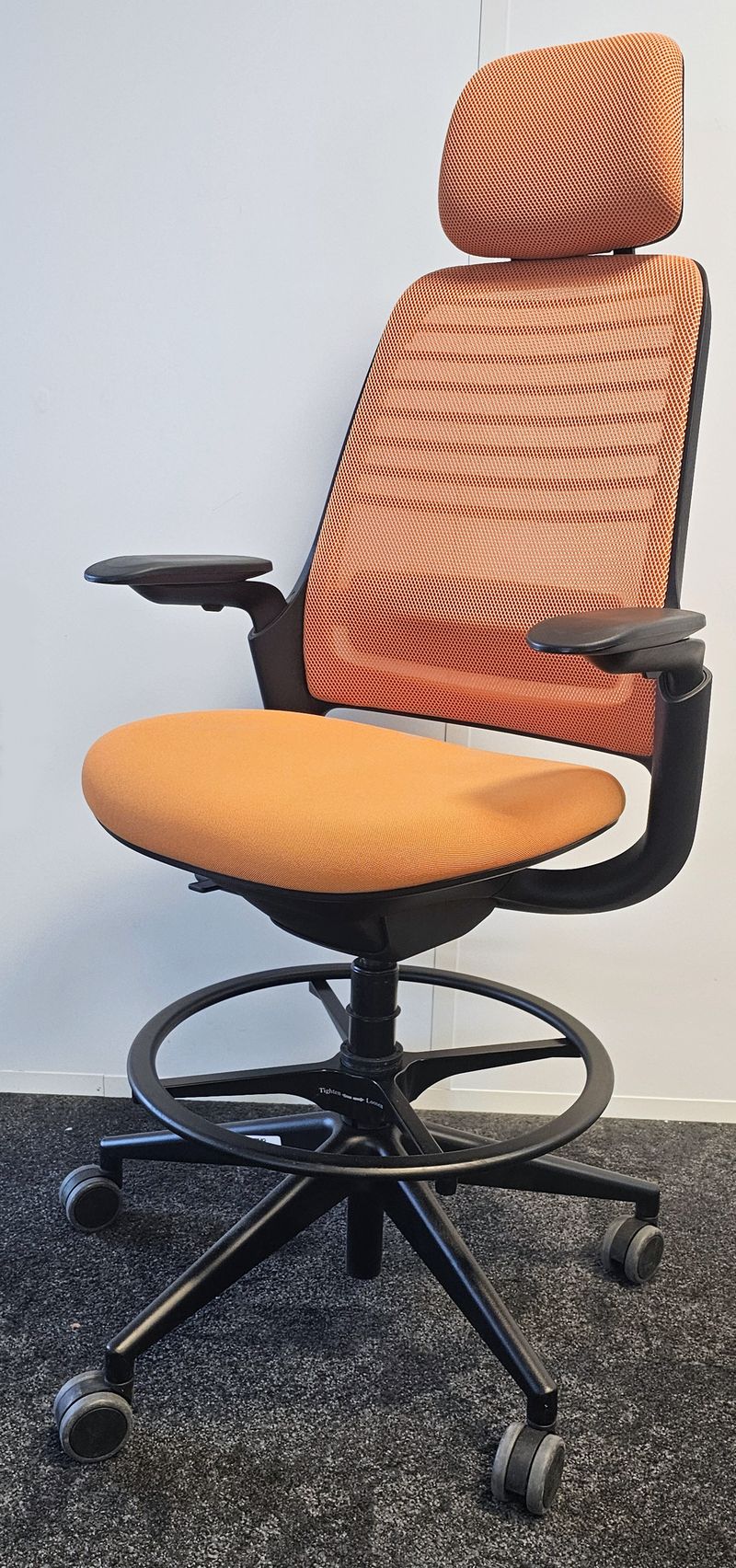 FAUTEUIL DE BUREAU HAUT A HAUTEUR AJUSTABLE ET TETIERE, SOUTIEN LOMBAIRE DE MARQUE STEELCASE MODELE SERIES 1 DOSSIER EN RESILLE DE COULEUR ORANGE, ASSISE ET TETIERE EN TISSU DE COULEUR ORANGE REPOSANT SUR UN PIETEMENT ETOILE A ROULETTES ET UN REPOSE PIED EN ACIER LAQUE NOIR. HAUTEUR MIN : 130 CM ; HAUTEUR MAX : 148 CM ; 64 X 64 CM. 2 UNITES. VENDU A L'UNITE AVEC FACULTE DE REUNION. LOCALISATION -> BAT A : 2 S, RDC E