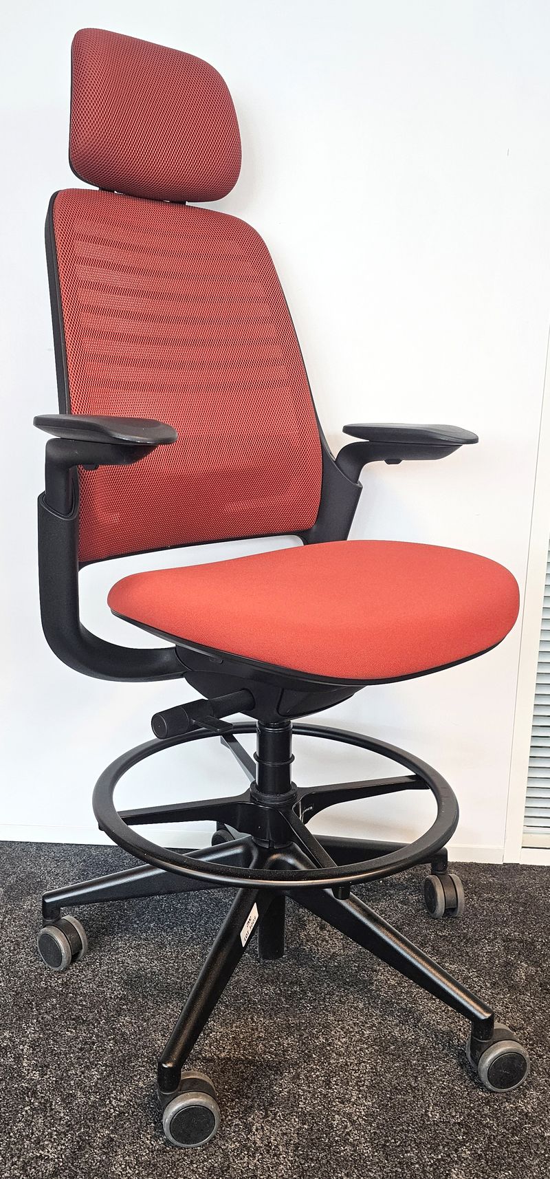 FAUTEUIL DE BUREAU HAUT A HAUTEUR AJUSTABLE ET TETIERE, SOUTIEN LOMBAIRE DE MARQUE STEELCASE MODELE SERIES 1 DOSSIER EN RESILLE DE COULEUR ROUGE, ASSISE ET TETIERE EN TISSU DE COULEUR ROUGE REPOSANT SUR UN PIETEMENT ETOILE A ROULETTES ET UN REPOSE PIED EN ACIER LAQUE NOIR. HAUTEUR MIN : 130 CM ; HAUTEUR MAX : 148 CM ; 64 X 64 CM. 3 UNITES. VENDU A L'UNITE AVEC FACULTE DE REUNION. LOCALISATION -> BAT A : 2 S