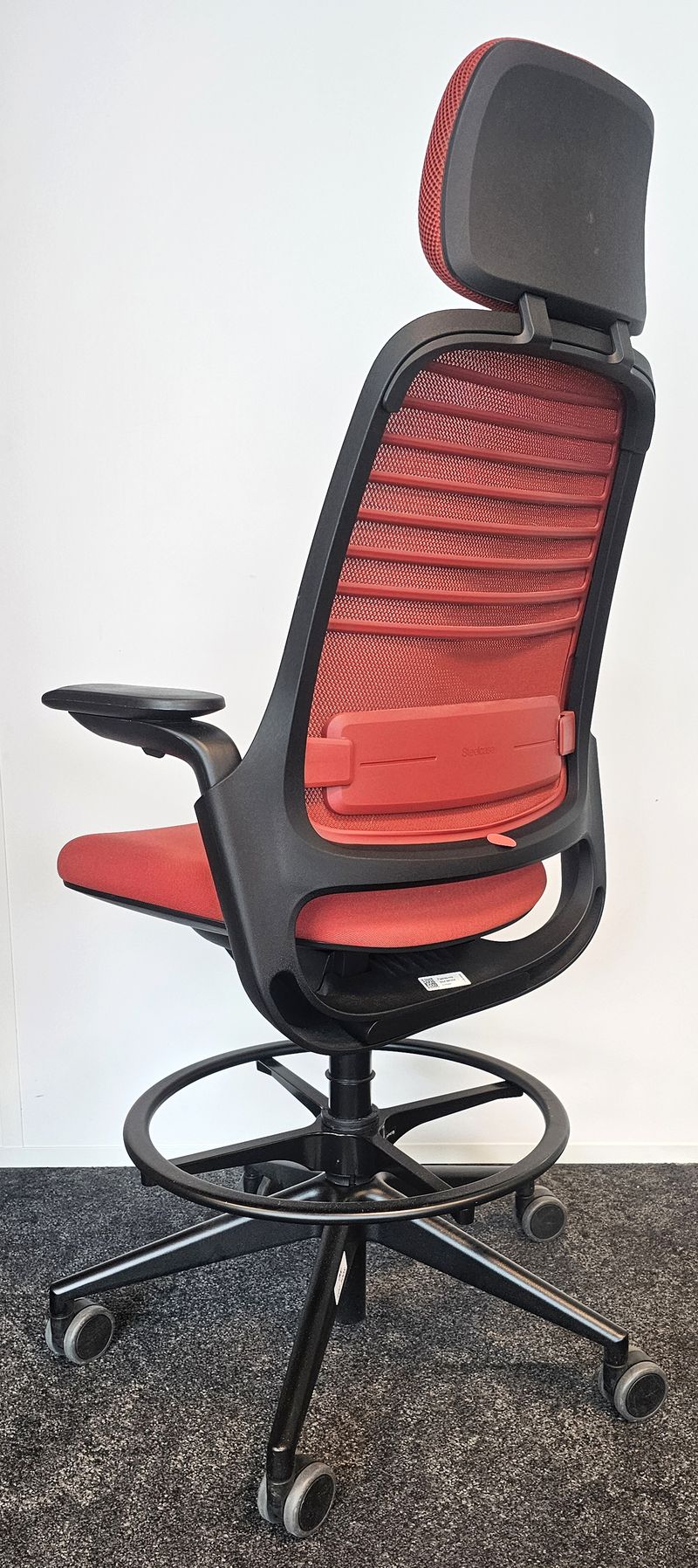 FAUTEUIL DE BUREAU HAUT A HAUTEUR AJUSTABLE ET TETIERE, SOUTIEN LOMBAIRE DE MARQUE STEELCASE MODELE SERIES 1 DOSSIER EN RESILLE DE COULEUR ROUGE, ASSISE ET TETIERE EN TISSU DE COULEUR ROUGE REPOSANT SUR UN PIETEMENT ETOILE A ROULETTES ET UN REPOSE PIED EN ACIER LAQUE NOIR. HAUTEUR MIN : 130 CM ; HAUTEUR MAX : 148 CM ; 64 X 64 CM. 3 UNITES. VENDU A L'UNITE AVEC FACULTE DE REUNION. LOCALISATION -> BAT A : 2 S