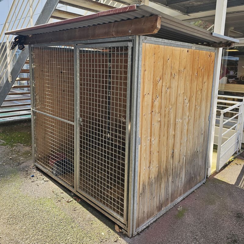 CHENIL OU BOX POUR CHIEN AVEC TOIT EN TAULE ONDULEE REPOSANT SUR UNE STRUCTURE EN PIN ET EN ACIER GALVANISE AVEC UNE GRILLE EN FACADE EN ACIER GALVANISE OUVRANT PAR UNE PORTE AVEC FERMETURE PAR CADENAS, SOL EN BOIS. 197 X 244 X 190 CM. LOCALISATION -> BAT FK EXT.