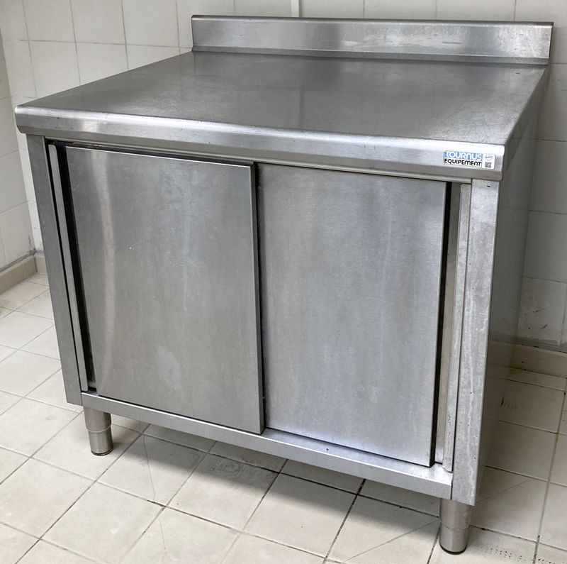 MEUBLE DE PREPARATION ADOSSE EN INOX ALIMENTAIRE DE MARQUE TOURNUS EQUIPEMENT  OUVRANT PAR 2 PORTES COULISSANTES SUR 1 ETAGERE ET REPOSANT SUR 4 PIEDS. 100 X 100 X 80 CM.