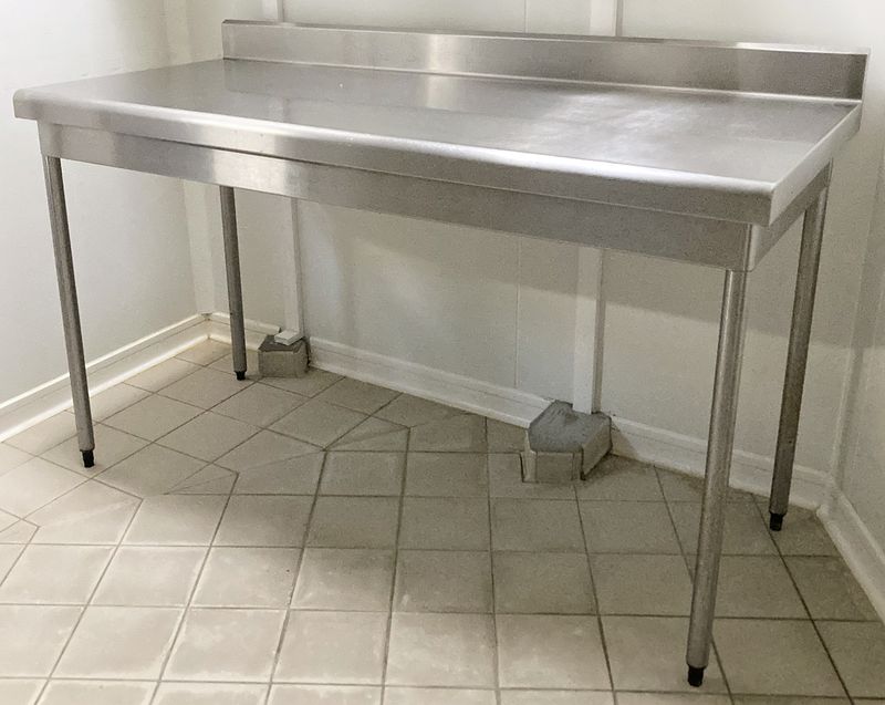 TABLE DE PREPARATION ADOSSEE EN INOX ALIMENTAIRE REPOSANT SUR 4 PIEDS. 100 X 160 X 70 CM.