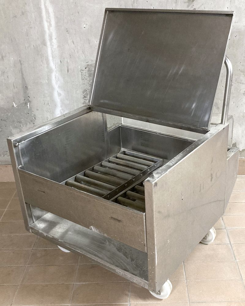 CHARIOT A ROULEAUX EN INOX ALIMENTAIRE OUVRANT EN FACADE PAR UNE TRAPPE EN INOX ALIMENTAIRE ET PAR DERRIERE PAR UNE TRAPPE EN PLASTIQUE TRANSPARENT SUR UN ESPACE AVEC 2 RANGEES DE 9 ROULEAUX EN INOX ET REPOSANT SUR 4 ROULETTES DIRECTIONNELLES EN NYLON BLANC. 75 X 61 X 62 CM.