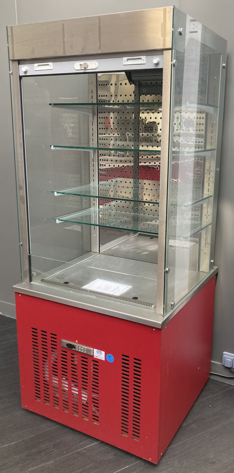 VITRINE DE SERVICE REFRIGEREE POSITIVE DE MARQUE VAUCONSTANT EN INOX ALIMENTAIRE, VERRE ET BOIS LAQUE ROUGE OUVRANT PAR UN RIDEAU EN PLASTIQUE GRIS SUR 4 ETAGERES EN VERRE. GROUPE FROID INTEGRE. AVEC CLE. 193 X 82 X 80 CM.