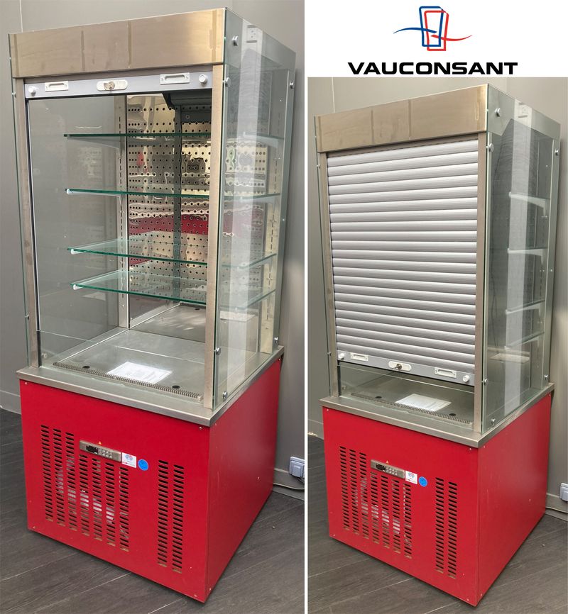 VITRINE DE SERVICE REFRIGEREE POSITIVE DE MARQUE VAUCONSTANT EN INOX ALIMENTAIRE, VERRE ET BOIS LAQUE ROUGE OUVRANT PAR UN RIDEAU EN PLASTIQUE GRIS SUR 4 ETAGERES EN VERRE. GROUPE FROID INTEGRE. AVEC CLE. 193 X 82 X 80 CM.