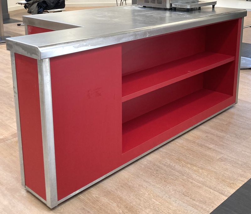 BUFFET DE MARQUE VAUCONSTANT EN INOX ALIMENTAIRE, VERRE ET BOIS LAQUE ROUGE PLATEAU EN INOX AVEC NICHE A 2 NIVEAUX EN FACADE ET TRAPPE DE SERVICE COMPRENANT 4 PRISES 230V. 86 X 200 X 100 CM.