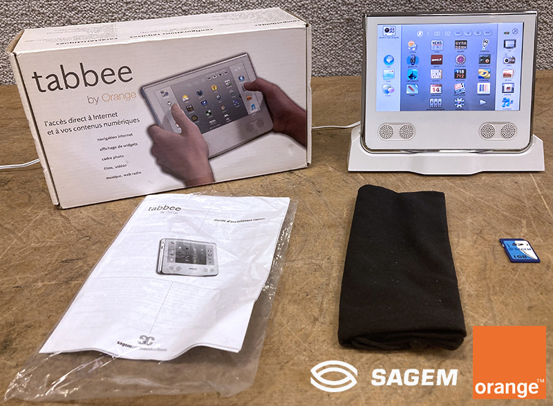 TABLETTE TACTILE 7 POUCES DE MARQUE SAGEM MODELE ORANGE TABBEE 253164241 AVEC SA STATION D'ACCUEIL, SON ALIMENTATION, 1 CARTE MEMOIRE SD 1GO, SON MODE D'EMPLOI ET SA HOUSSE DE PROTECTION. DANS SON EMBALLAGE D'ORIGINE.