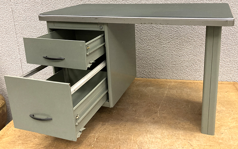 PETIT BUREAU DE DACTYLOGRAPHIE DES ANNEES 1950 EN ACIER LAQUE GRIS VERT DE MARQUE BURAM, PLATEAU RECTANGULAIRE A COINS ARRONDIS CERCLE DE ACIER CHROME ET SOUS-MAIN EN VINYLE DE CLOUEUR GRIS VERT REPOSANT SUR 2 TIROIRS. 70 X 110 X 55.5 CM.