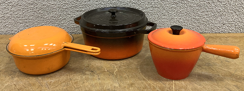 3 USTENSILES DE CUISINE EN FONTE EMAILLEE DE COULEUR ORANGE ET FLAME ET ORANGE DONT : 1 FAIT-TOUT ET COUVERCLE A MIJOTE DE MARQUE STAUB. 26 CM. 2 CASSEROLES ET COUVERCLES DE MARQUE LE CREUSET. 22 CM ET 17 CM (ECLAT SUR LE COUVERCLE).